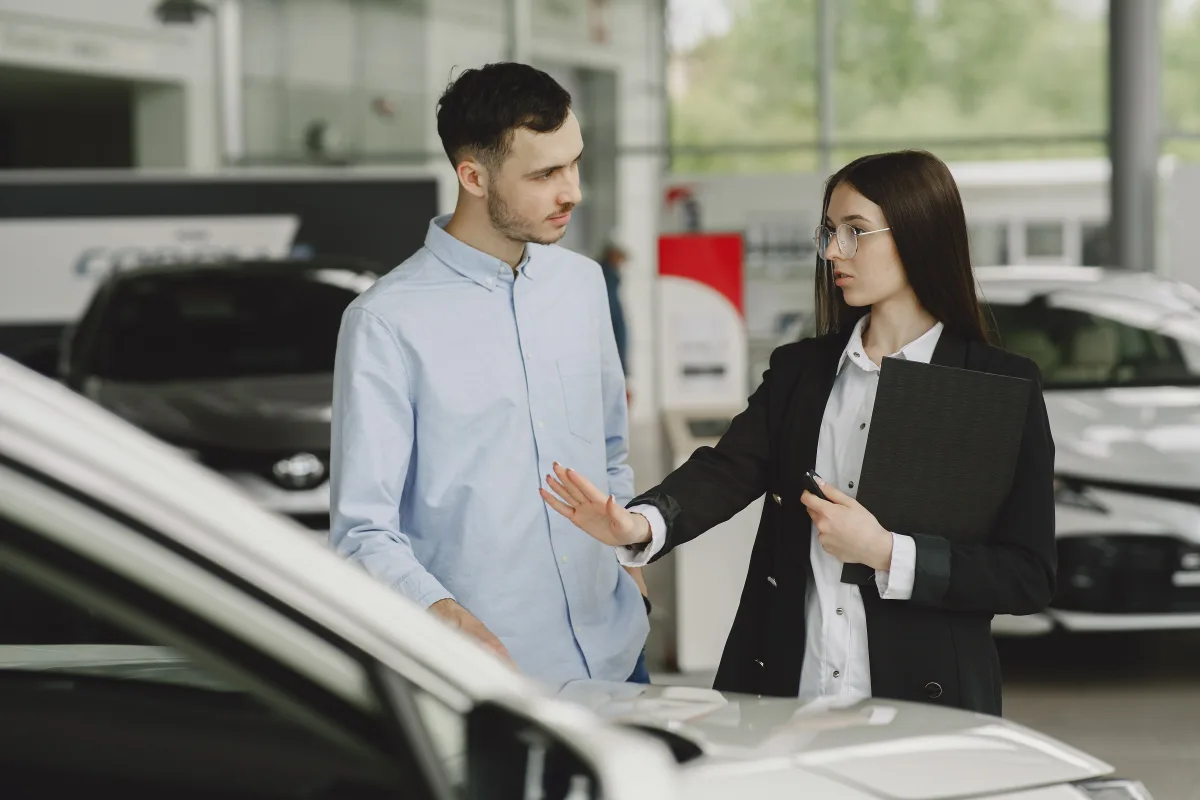 Salesperson discussing vehicle features with a customer inside a dealership