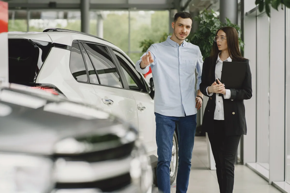 Customer and salesperson reviewing a used car purchase at a modern dealership