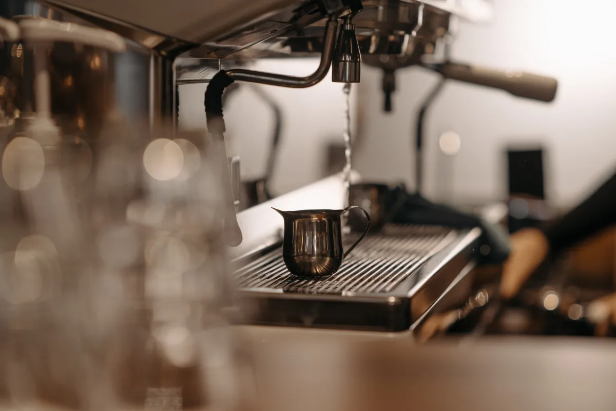 Close-up of a semi-automatic espresso machine with a metal steam pitcher — espresso machines 2026