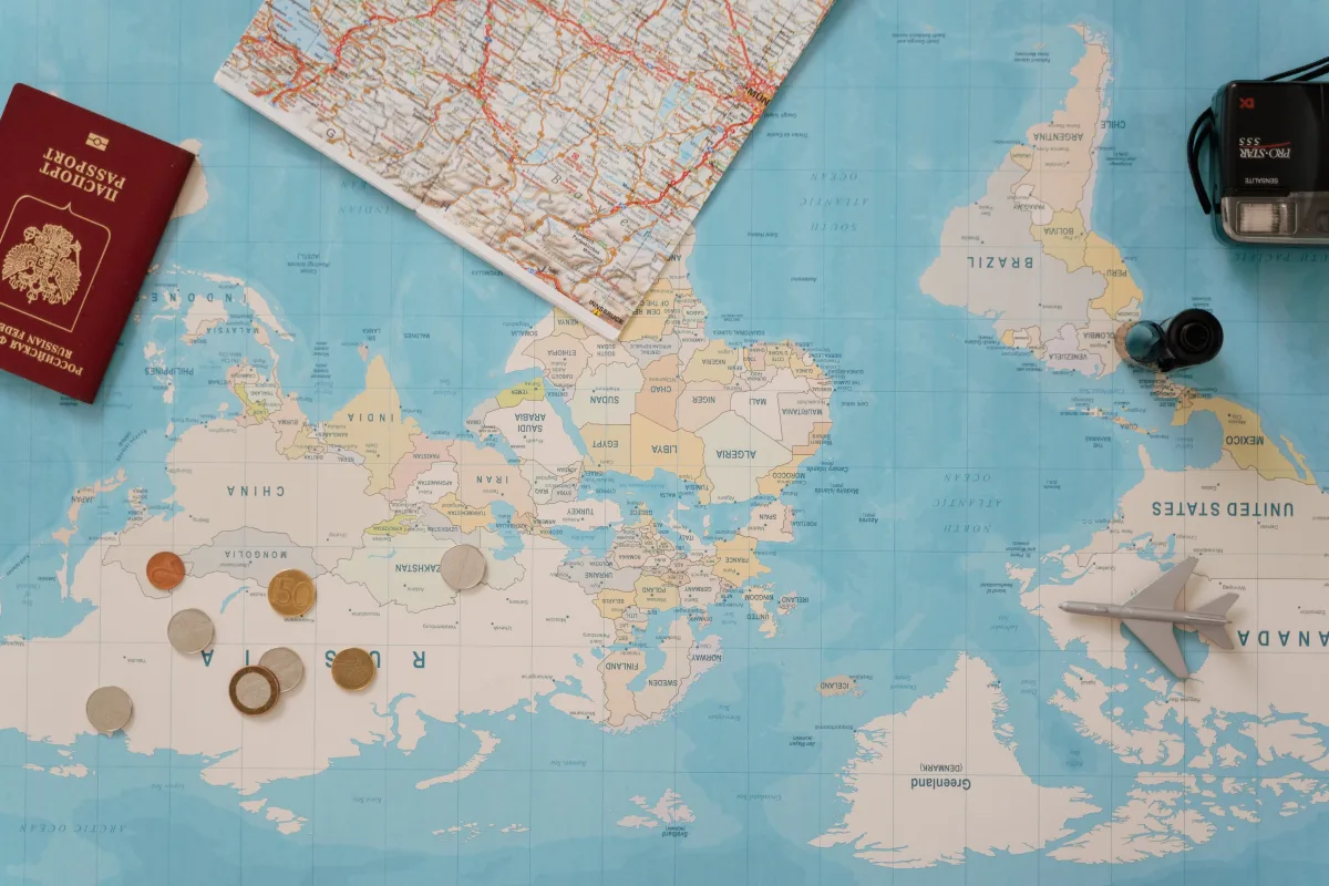 Flat lay of a passport, world map, and camera for 2026 travel planning