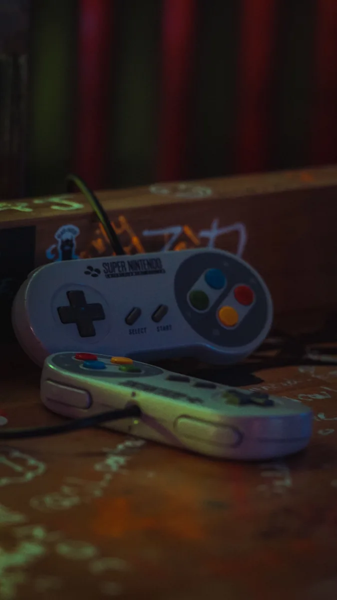 Close-up of vintage Super Nintendo SNES game controllers on a dark wooden surface