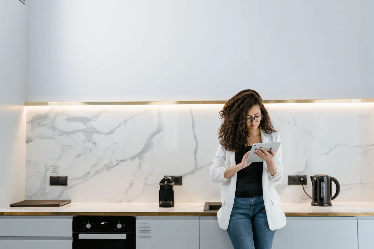 Person controlling smart kitchen appliances via smartphone app