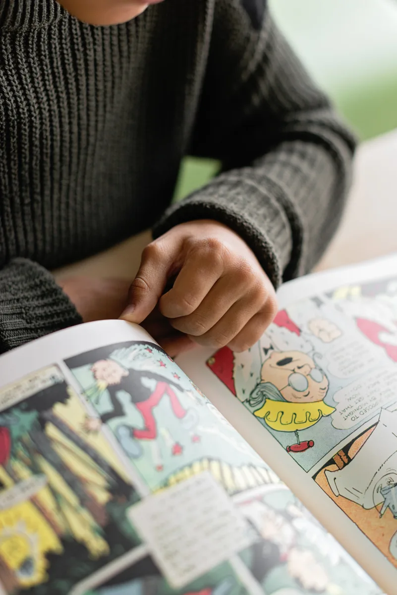 Close-up of a person reading a colorful comic book
