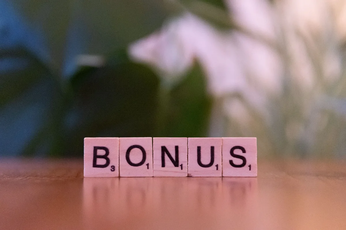 Bonus spelled in Scrabble tiles representing sign-up bonuses and earning velocity in rewards programs
