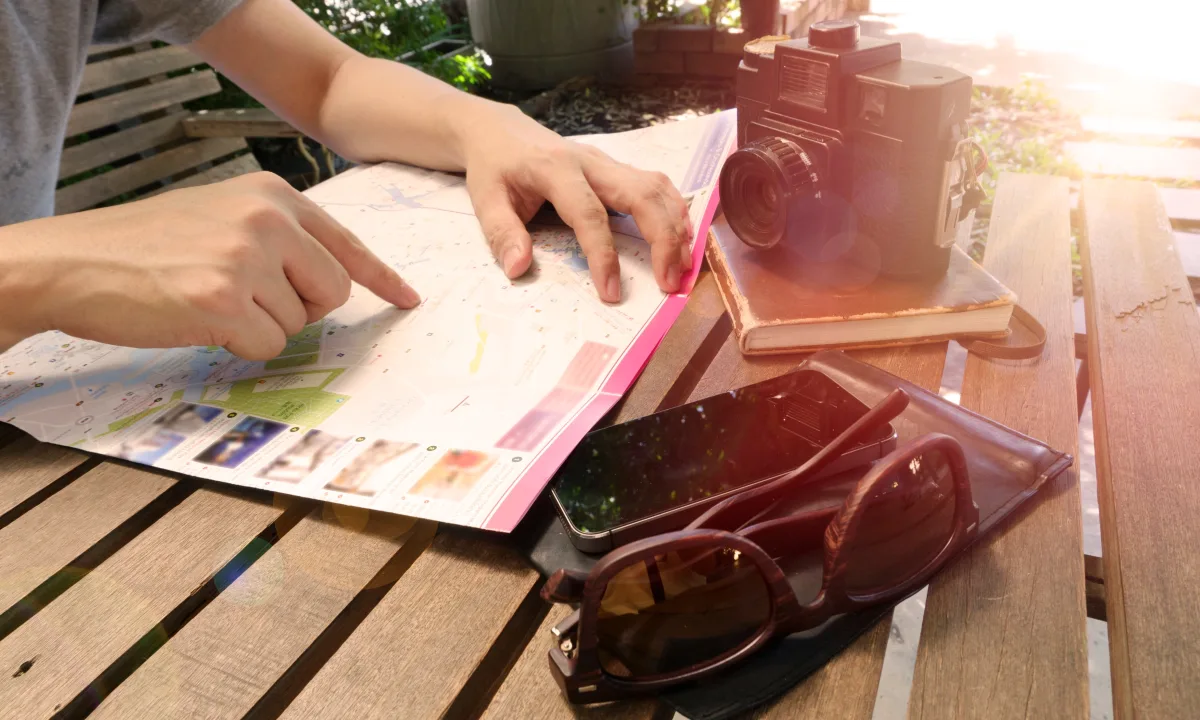 Traveler reviewing a hotel map and itinerary at a wooden table
